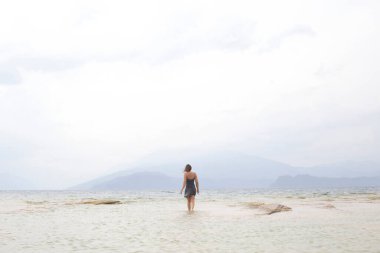 Yalnız kadın denizin ortasında sonsuzluğa doğru yürür.