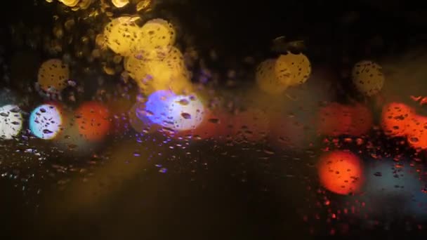 Zbliżenie kropel deszczu spływających po przedniej szybie samochodu — Wideo stockowe