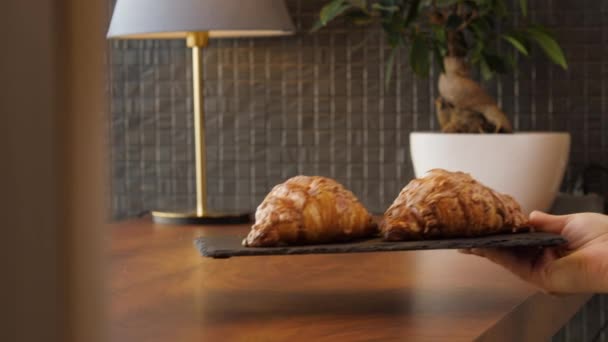Dva čerstvé lahodné croissanty jsou umístěny na dřevěném stole — Stock video