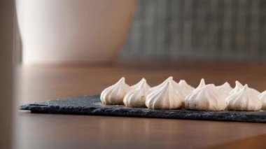 Siyah tepside bir sürü beyaz kremalı pasta