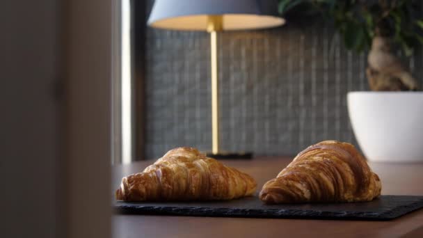 Dva čerstvé lahodné croissanty na podnose na stole — Stock video