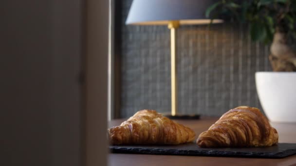 Dva čerstvé lahodné croissanty na podnose na stole — Stock video