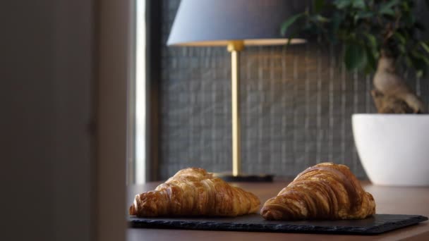 Dva čerstvé lahodné croissanty na podnose na stole — Stock video