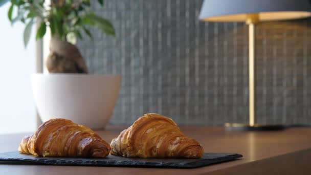 Dva čerstvé lahodné croissanty na podnose na stole — Stock video