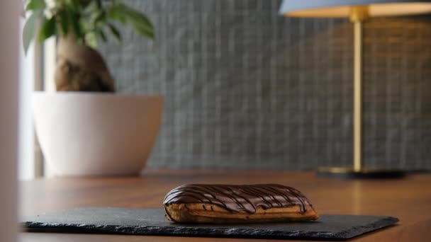 Retrato de una deliciosa eclair cubierta con glaseado de chocolate — Vídeos de Stock