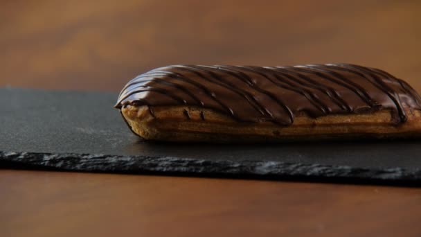 Close-up de um delicioso eclair coberto com esmalte de chocolate — Vídeo de Stock