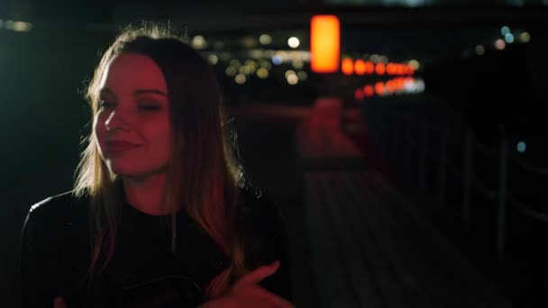 Retrato de uma jovem bonita fica em uma rua de luz vermelha — Vídeo de Stock