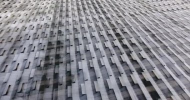 Geniş, modern bir seranın cam çatısının üst manzarası.