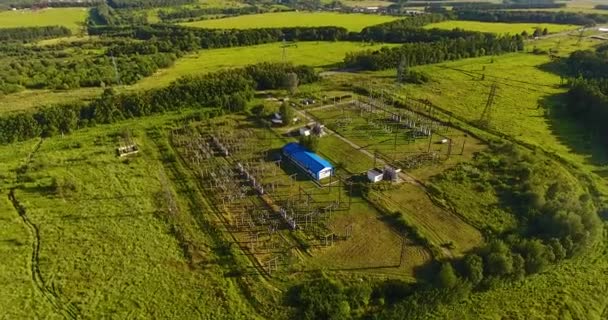 Luchtfoto op elektrisch onderstation met een groot gebouw en transformatoren — Stockvideo