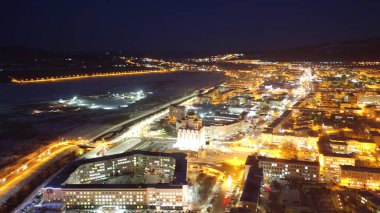 Kışın akşam şehri üzerinde uçuyorum.