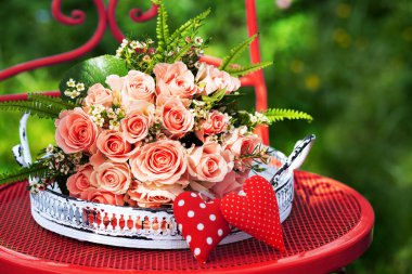 Bahçe sandalyesinde pembe güller çiçek buketi