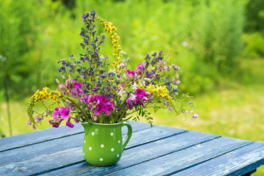 Bahçe masasında yabani çiçek buketi