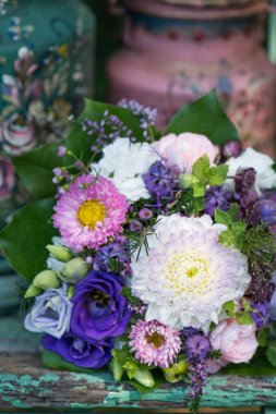 Eski ahşap bir bahçe sandalyesinde renkli bir çiçek buketi