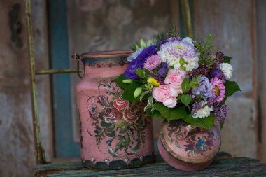 Eski ahşap bir bahçe sandalyesinde renkli bir çiçek buketi