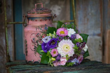 Eski ahşap bir bahçe sandalyesinde renkli bir çiçek buketi