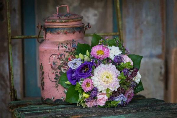 Eski ahşap bir bahçe sandalyesinde renkli bir çiçek buketi