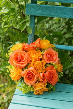 Çiçek aranjmanı bahçe sandalyesinde.