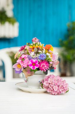 Renkli yabani çiçekler eski bir kahve fincanında