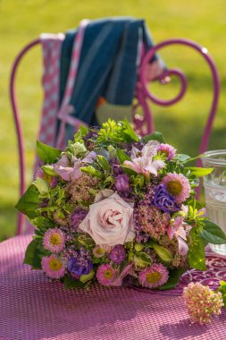 Bahçe masasında renkli bir çiçek buketi