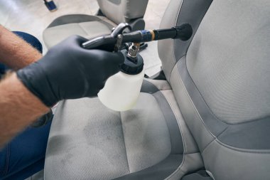 Detaylı servis çalışanı yüksek basınçlı silahla kimyasal yıkama yapıyor.