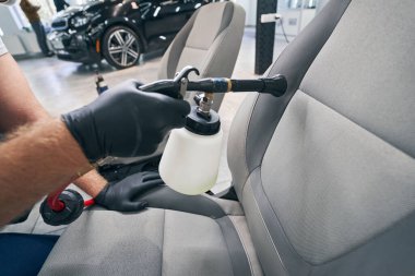 Araba servisindeki kirli koltukları yüksek basınçlı temizleme silahıyla yıka.
