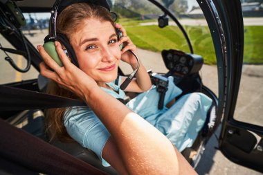 Neşeli bayan pilot kalkıştan önce kulaklığı ayarlıyor.