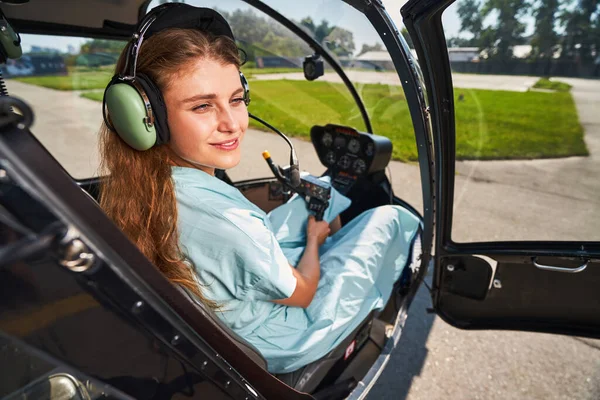 Özel helikopterin kokpitinde hayal kuran mutlu havacı kadın.