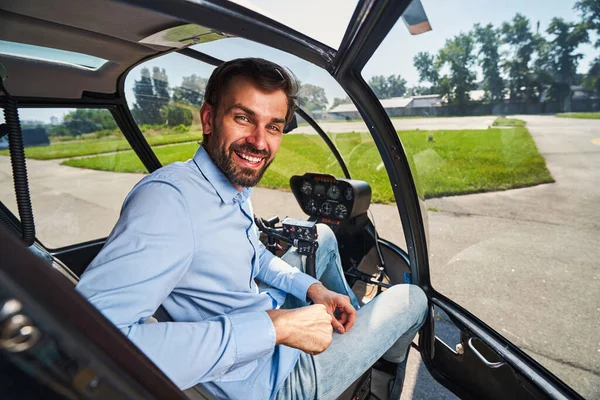 Joyful airman posing for camera in helicopter cabin — Stock Photo, Image