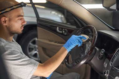 Tamir atölyesinde araba temizleme personeli.