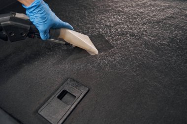 Arabanın içinde taşınabilir elektrikli süpürge var.