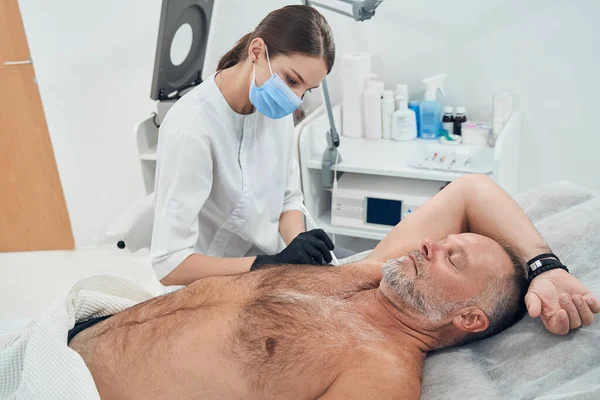 Man som får underarmsbehandling på kosmetologiska kliniken — Stockfoto