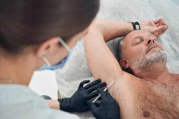 Mężczyzna leczony pod pachami w klinice kosmetologii — Zdjęcie stockowe