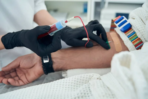 Medicinsk laboratoriearbetare som tar blodprov från patienten — Stockfoto