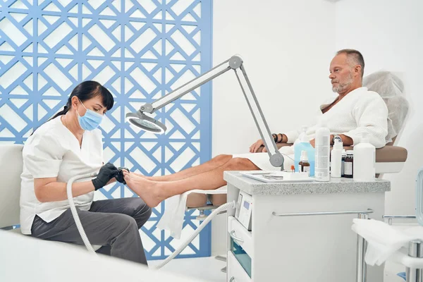 Man met hardware pedicure procedure in kosmetologie salon — Stockfoto