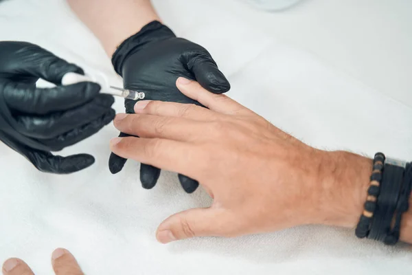 Manicura aplicando suero en las uñas del hombre después de la manicura —  Fotos de Stock