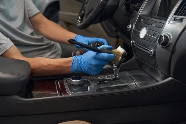 Trabalhador da indústria automóvel detalhando cuidadosamente o interior do carro — Fotografia de Stock