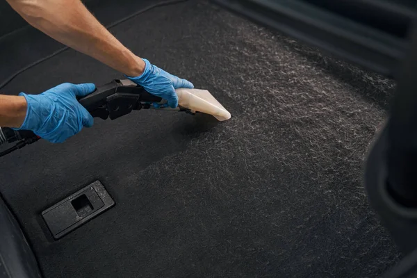 전문 직공 이 더러운 자동차간에 젖은 진공소제기를 사용하는 모습 — 스톡 사진