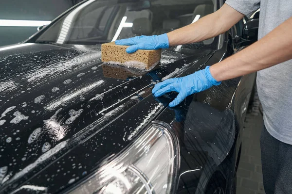 Männlicher Arbeiter wäscht Auto mit seifigem Schwamm — Stockfoto