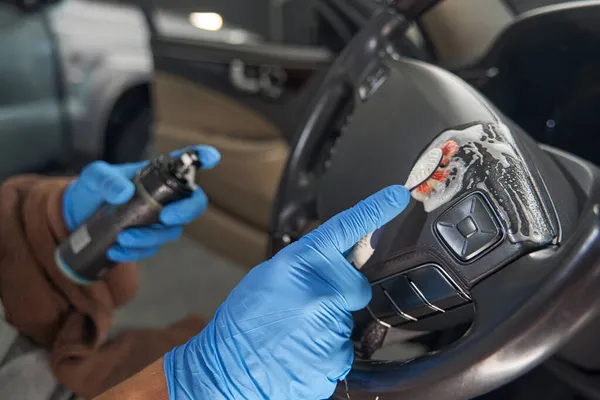 Autowaschanlage reinigt Lederlenkrad mit Bürste — Stockfoto