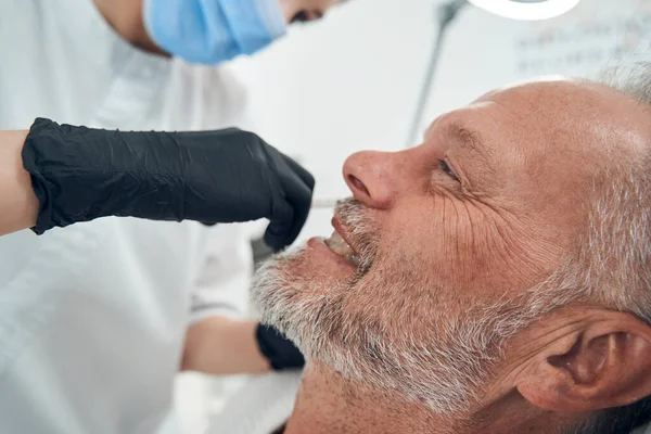 Uomo gioioso che ha la procedura di cura della pelle in clinica cosmetologica — Foto Stock