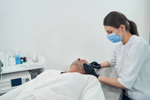 Man die huidverzorging krijgt in een kosmetologische kliniek — Stockfoto