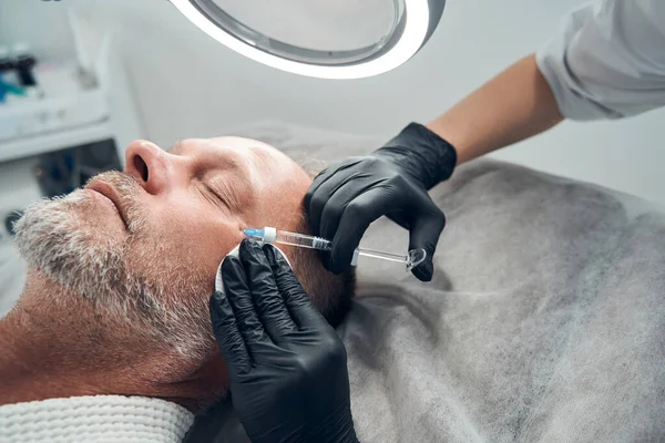 Homem recebendo injeção anti-envelhecimento no salão de cosmetologia — Fotografia de Stock