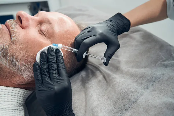 Uomo rasato ottenere l'iniezione in faccia al centro benessere — Foto Stock