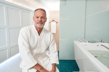 Kaplıca salonundaki masaj masasında oturan adam