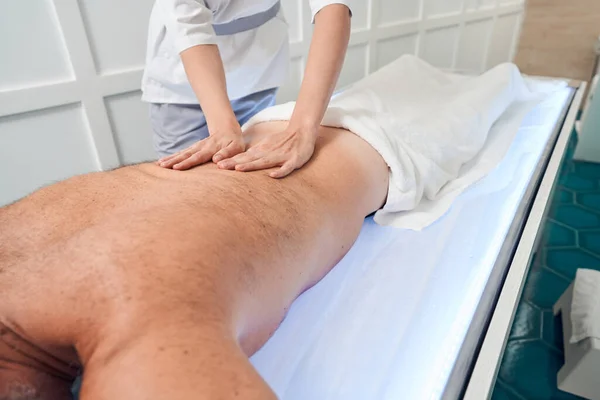Uomo che riceve massaggio alla schiena professionale nel salone spa — Foto Stock