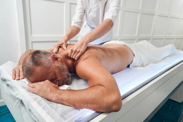 Massaggiatrice massaggio maschio indietro in spa salone — Foto Stock