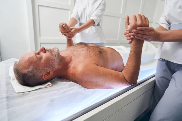 Homem barbudo tendo massagem de mão no salão de spa — Fotografia de Stock