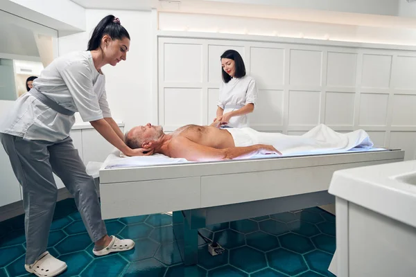 Cliente masculino recibiendo masaje terapéutico en salón de spa — Foto de Stock