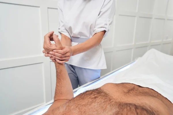 Мужчина с массажем рук в спа-центре — стоковое фото