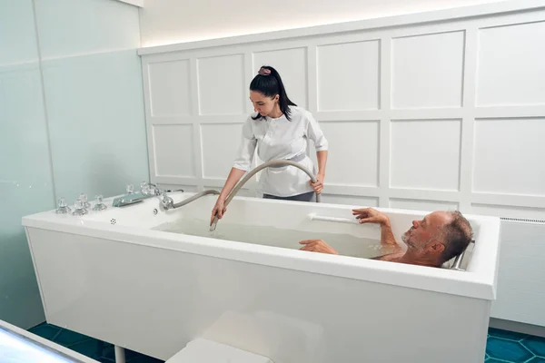 Hombre que tiene procedimiento de hidromasaje en el salón de spa — Foto de Stock